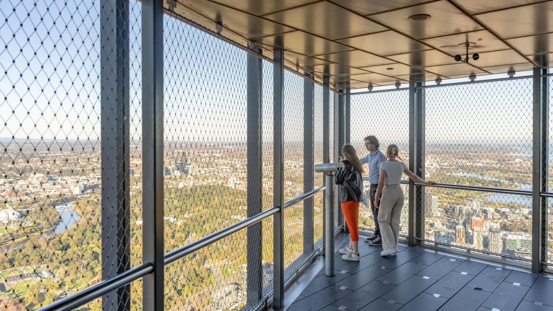 three locals on the outdoor observation deck on level 88 looking out at Melbourne Views